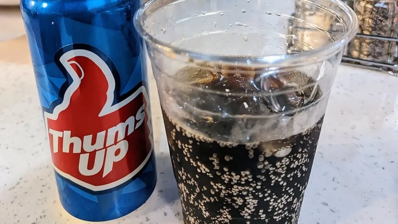 bottle and filled cup of Thums Up