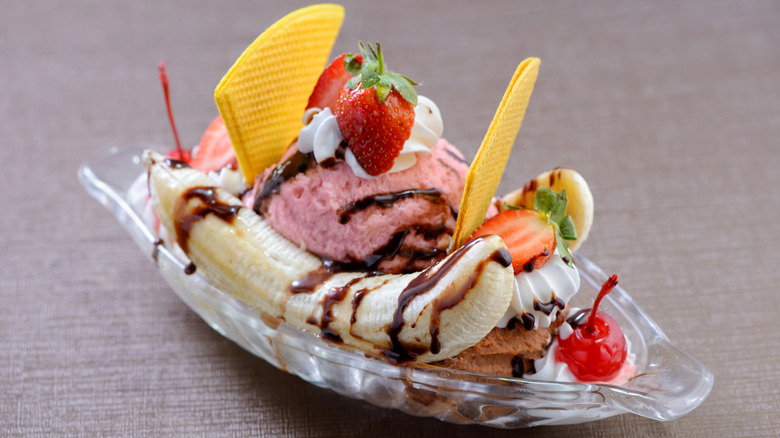 banana split with layers of icecream, whipped cream, and fruit in a clear dish