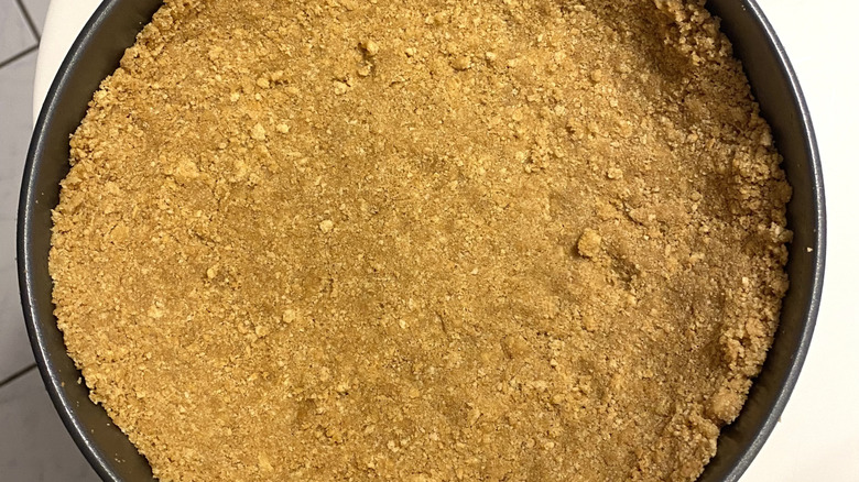 graham cracker crust in a pan waiting to be filled