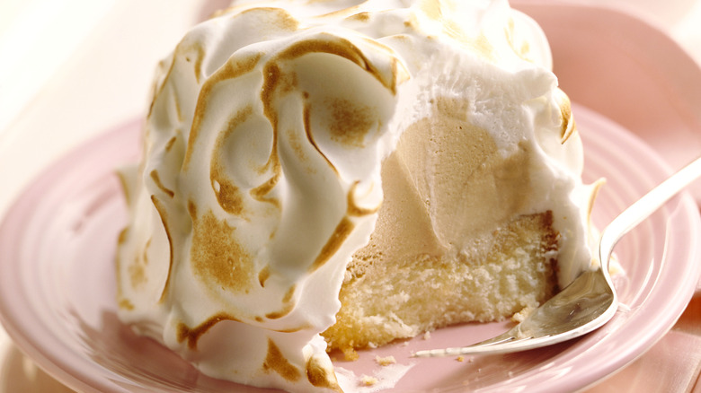 baked alaska dessert cut open on a pink plate