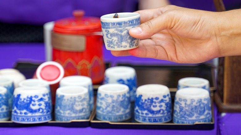 hand holding small teacup with delft pattern