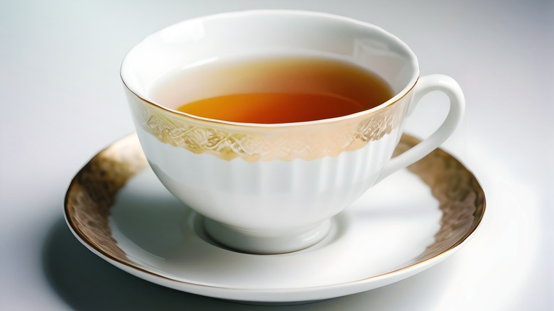 gold and white teacup and saucer