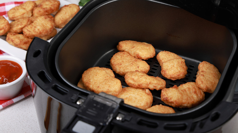 Chicken nuggets sitting in an air fryer basket