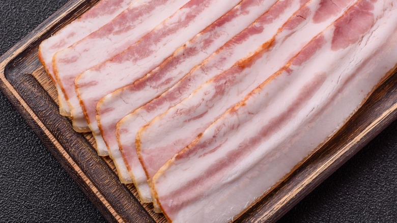 Raw bacon on a cutting board