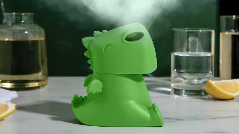 Green dinosaur figure sitting on counter with steam coming out of its nose