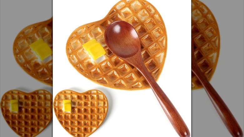 Realistic-looking heart-shaped waffle spoon rest with a pat of butter and a wooden spoon