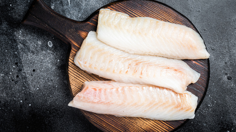 Black cod fillets on a round cutting board