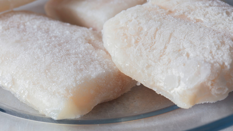 A pile of frozen cod fillets on a plate