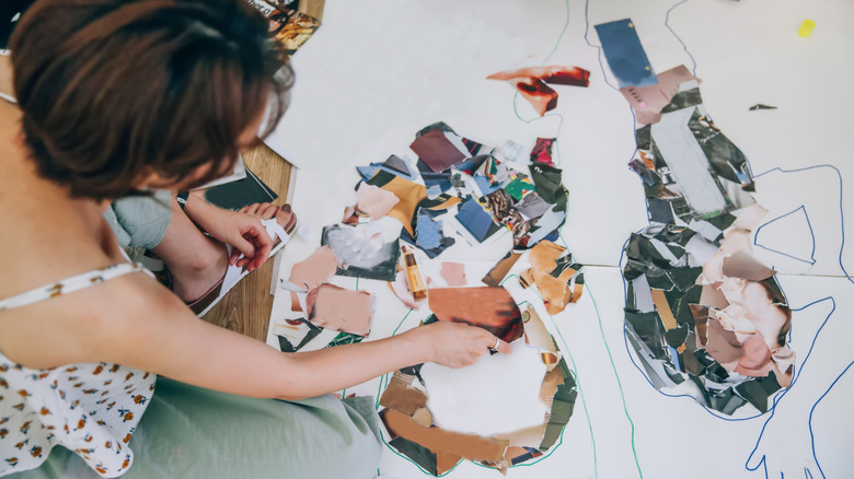 A woman assembling mosaic pieces on an outline