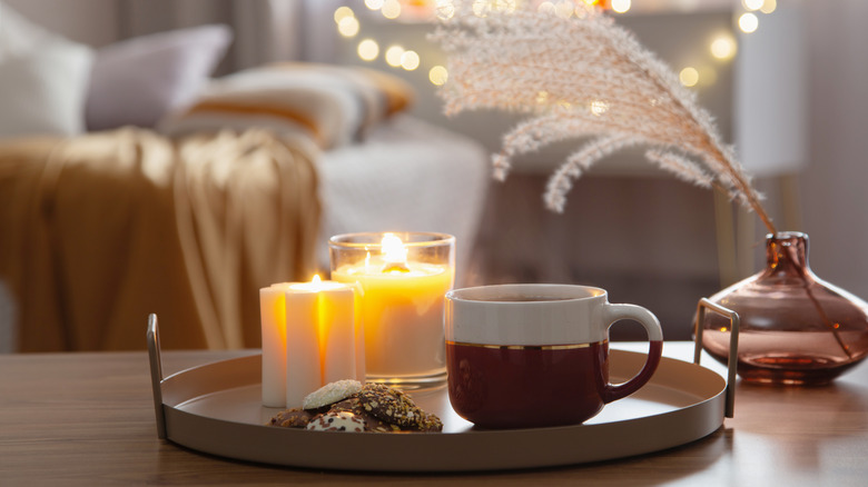 A mug and several candles on a tray