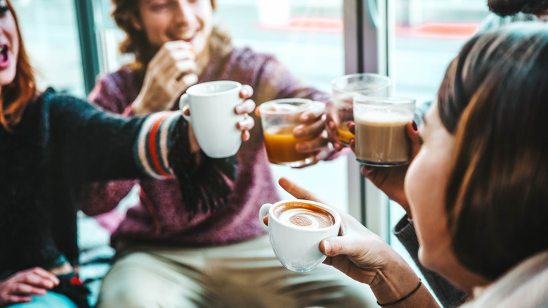 A group of friends toasting with coffee mugs