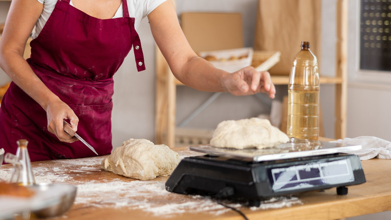 Baker weighing dough on a kitchen scale