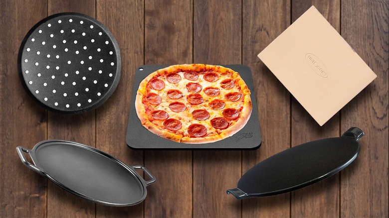 Variety of baking steels and stones surrounding pizza on baking stone