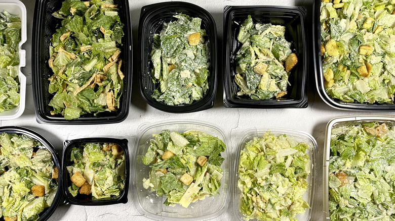 Assorted restaurant takeout Caesar salads in two rows