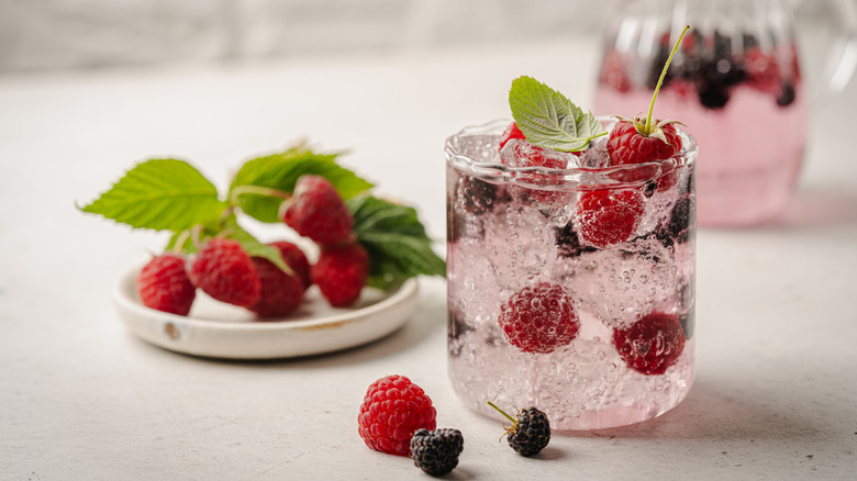 Sparkling cocktail with fresh raspberries and blackberries