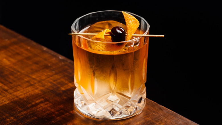 Classic Old Fashioned cocktail with orange swath and cherry garnish