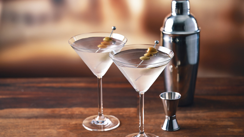 Chilled martinis with olive garnish and cocktail shaker