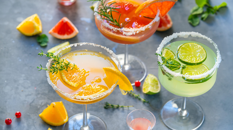 Various fruity martinis with fresh herb garnishes