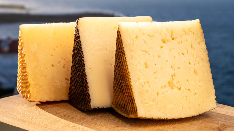 Cheese wedges lined up on board