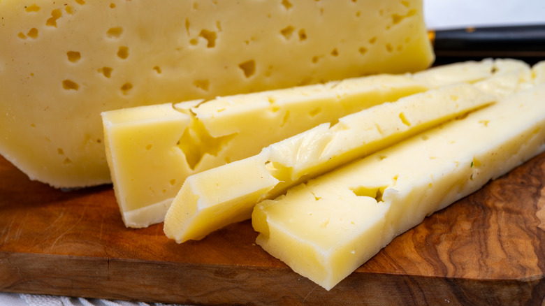 Asiago cheese slices on cutting board