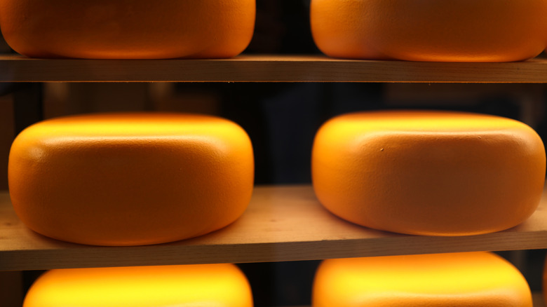 Cheese wheels stacked on shelf