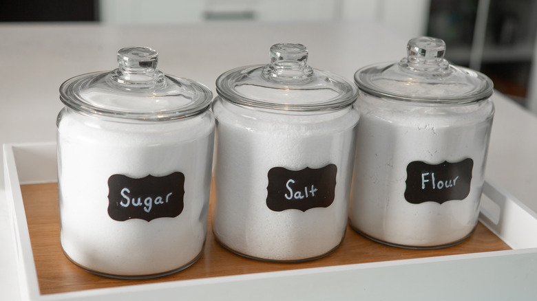 Glass jars full of sugar, salt, and flour