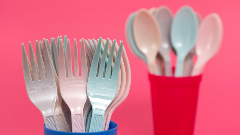 Cups full of plastic forks and spoons