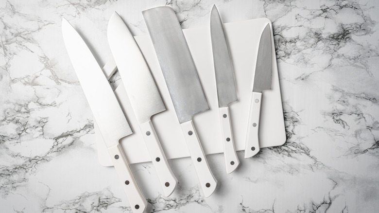 Set of kitchen knives on a white cutting board