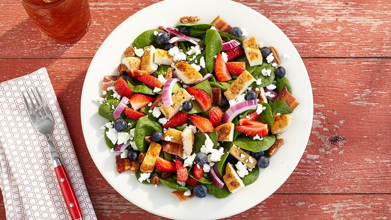 Cracker Barrel's Grilled Chicken n' Strawberry Spinach Salad sitting on a red wooden table