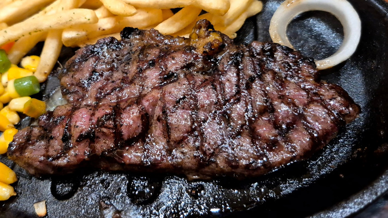 A sirloin steak from the grill on a cast iron skillet