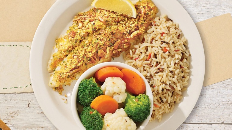 A plate of Cracker Barrell's Pecan Crusted Catfish with rice and vegetables