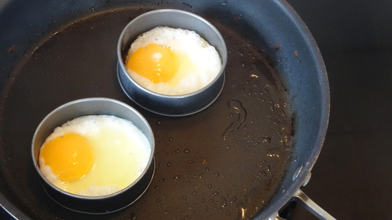 eggs within two egg rings in a pan