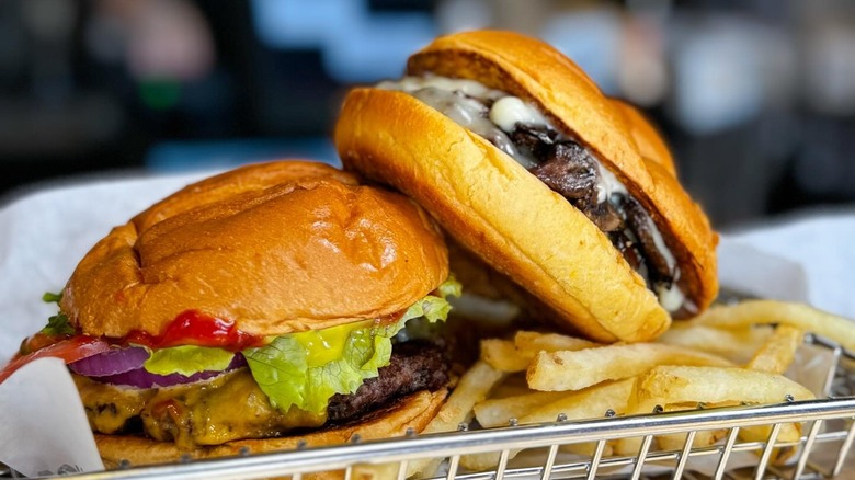 Two Smashburger burgers in a basket with fries