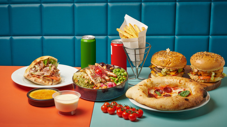 Burgers, fries, pizza, and salad on a counter