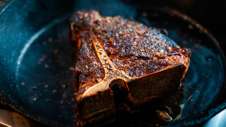 A t-bone steak in a cast iron skillet