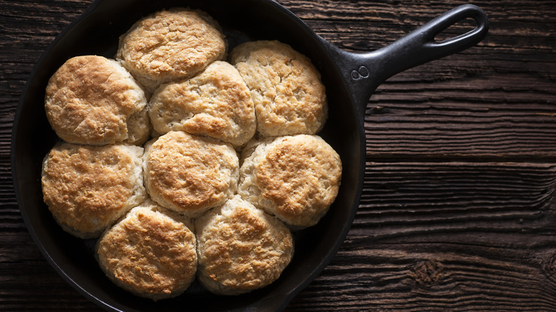 A skillet of biscuits on a wooden table