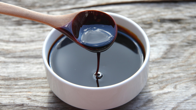 A bowl of molasses on a wood table