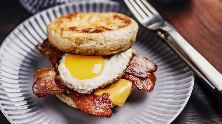 Plate with bacon, egg, and cheese, sandwich on an English muffin