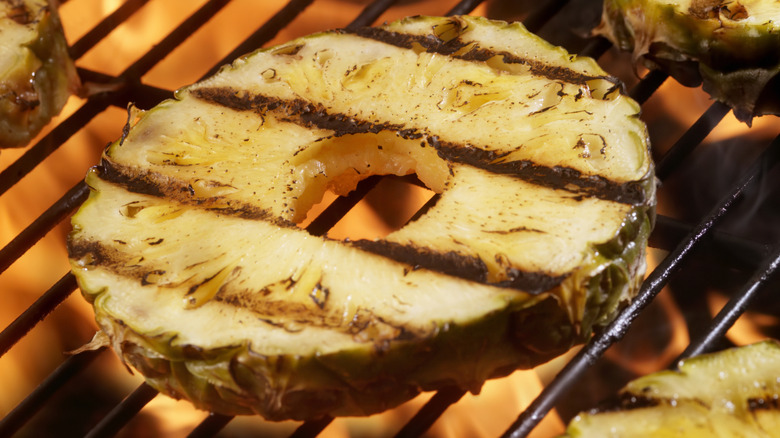 Pineapple rings cooking on fiery grill