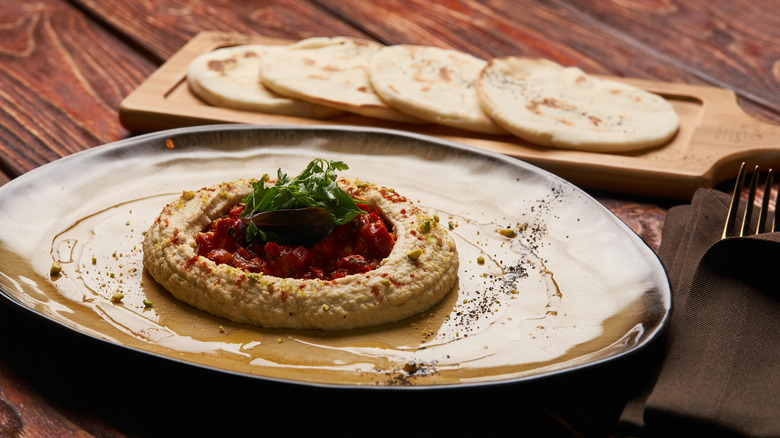 Plate with a ring of hummus around a dollop of harissa
