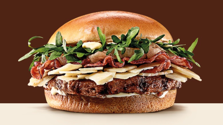 A Parmigiano Reggiano Burger from Burger King Italy in front of a dark background