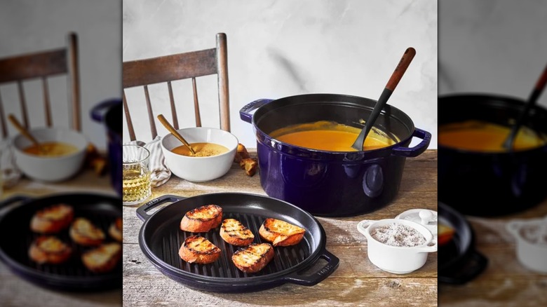 Large blue pot with soup and a tray of toasted bread