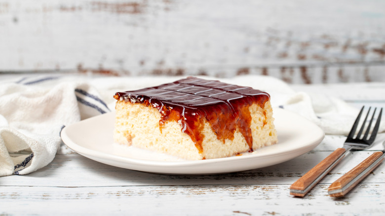 A slice of tres leches cake topped with caramel