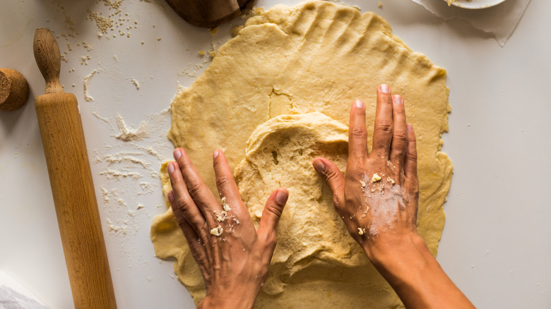 A person kneading pie dough