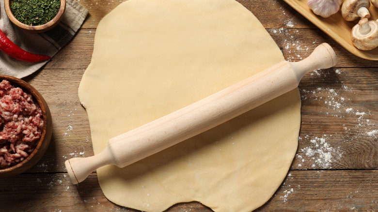 A piece of pie dough rolled out on a cutting board