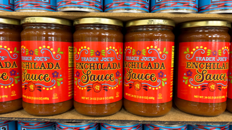 Jars of Trader Joe's enchilada sauce on a shelf at a store