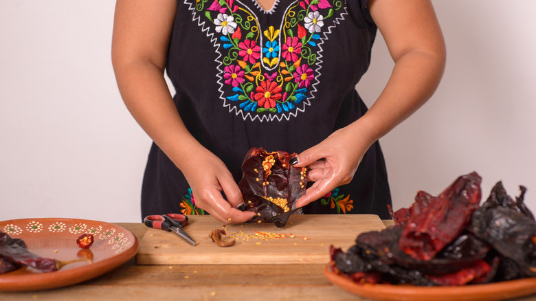 A person deseeding dried chilis
