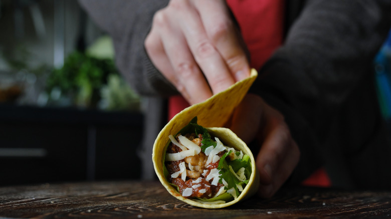 A person rolling a burrito
