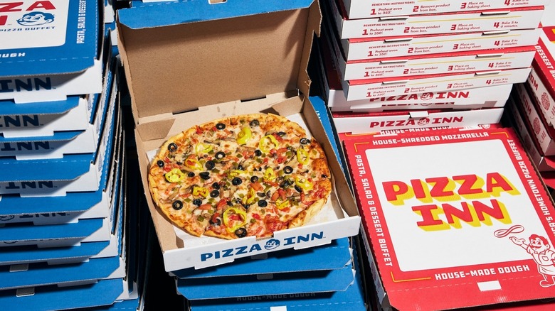 A pizza in a takeaway box from Pizza Inn