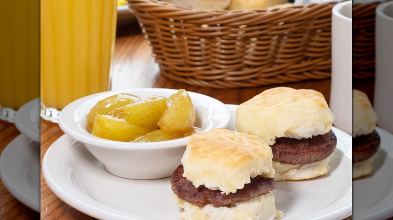 Biscuits with sausage and fried apples on a white plate
